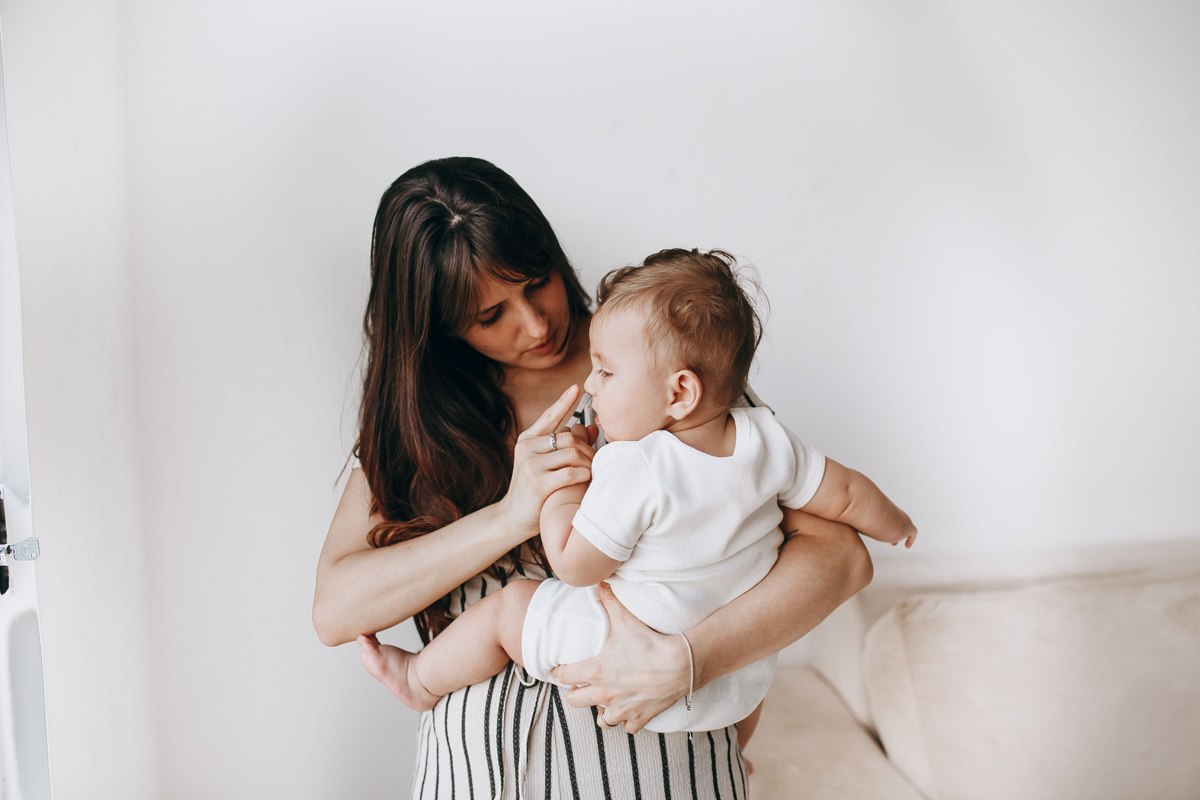 Une mère tenant son bébé à la maison.